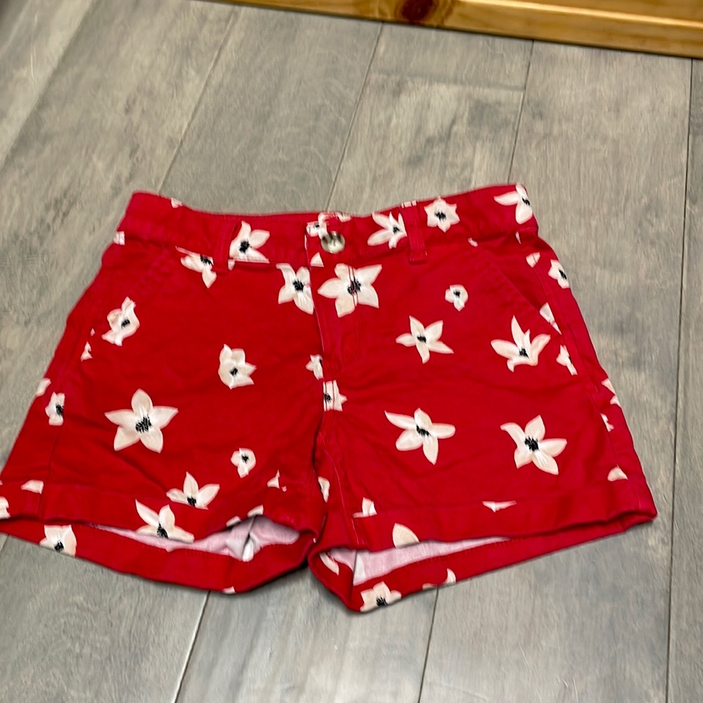 Red jean shorts with flower designs.